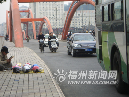 不少人在解放大桥上摆摊 叫卖摩托车头盔(图)