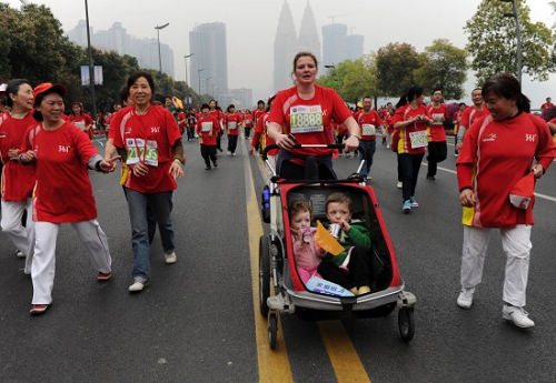2011重庆马拉松赛鸣枪开赛 母亲推着孩子马拉
